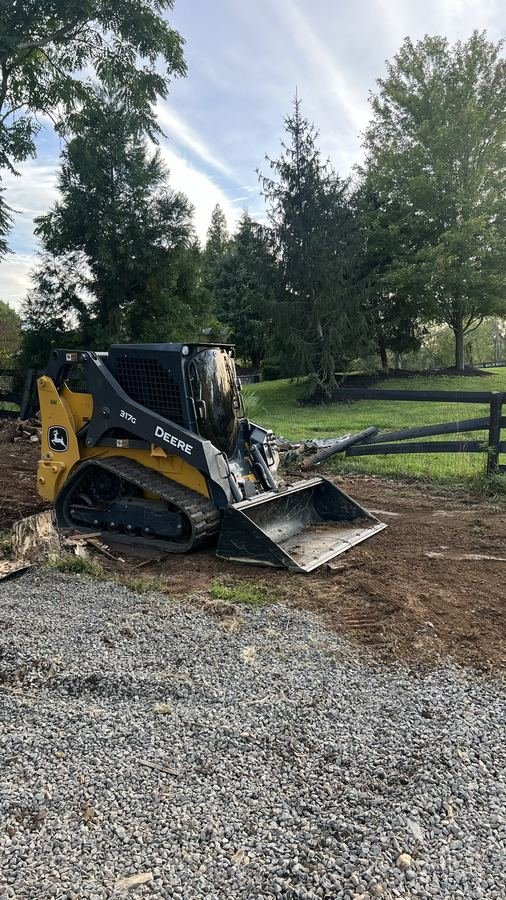 John Deere 317G finishing a graded gravel driveway area
